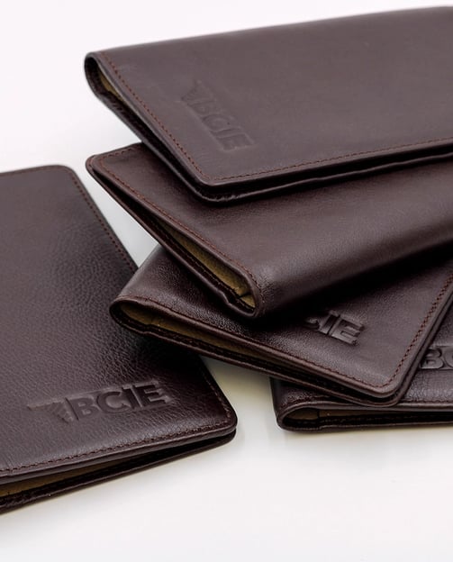 a group of four leather wallets with the word's name on it