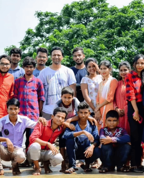 a group of people standing in front of a tree