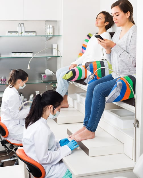 Two lady customers recieving pedicure services