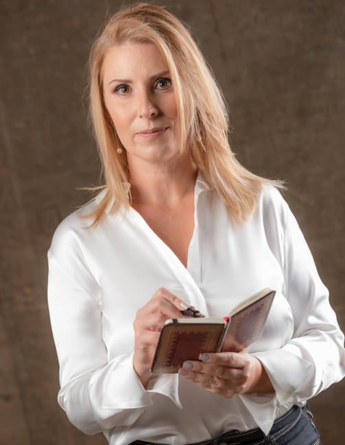 a woman in a white shirt and jeans is holding a book
