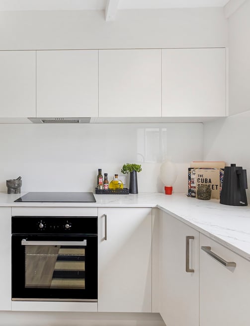 white modern kitchen with glass splashback
