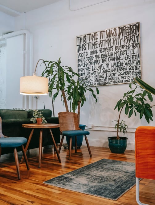 Decoração que une a natureza ao design, com plantas, iluminação e quadros bem posicionados.