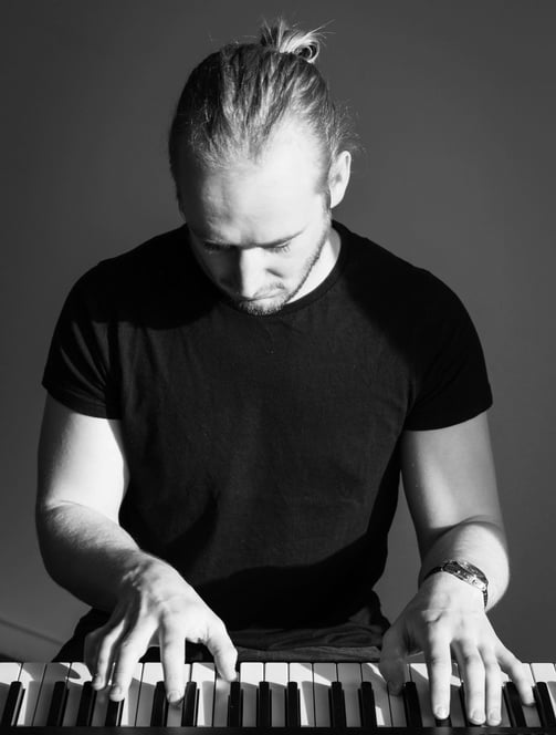 photo en noir et blanc d'un homme qui joue du piano