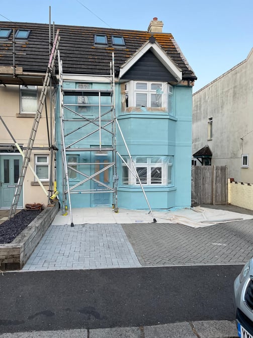 blue house after spraying by Rupert De La Mare