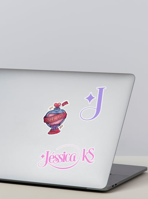 notebook com adesivos delicados com glitter e inicial e logo de tatuadora