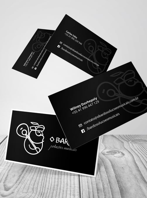 Cartões de visitas pretos com logo branco de produtora musical com homem barbudo segurando violão