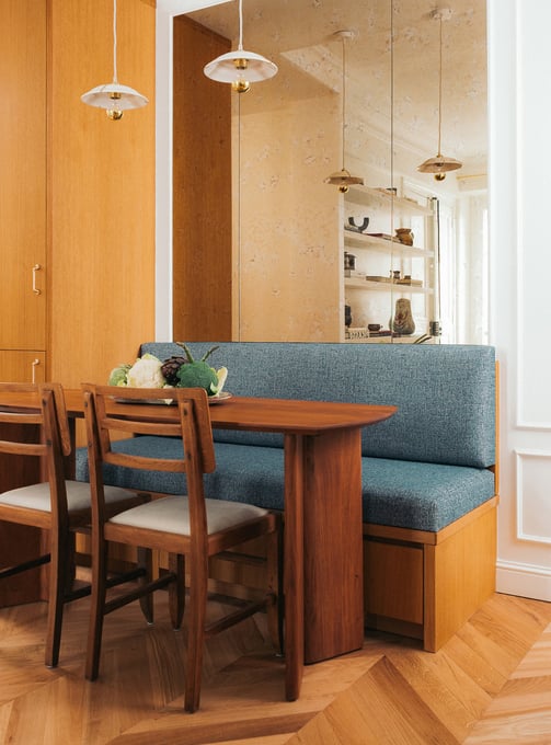 Coin repas avec banquette sur mesure, miroir vieilli, table en noyer et chaises Pierre Cruège
