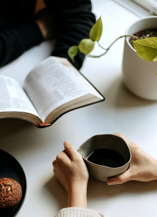 Deux personnes sont face à face, l'ambiance est détendue, avec un livre et un café