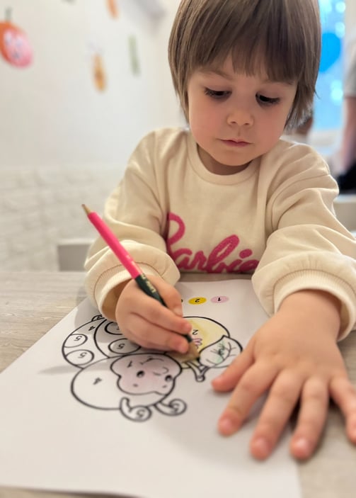 a young child is drawing on a piece of paper