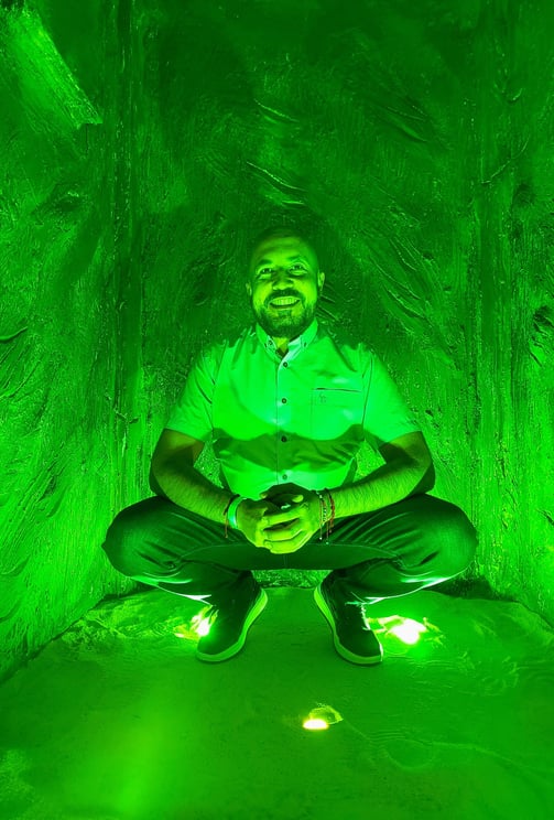 a man sitting in a tunnel with a green light