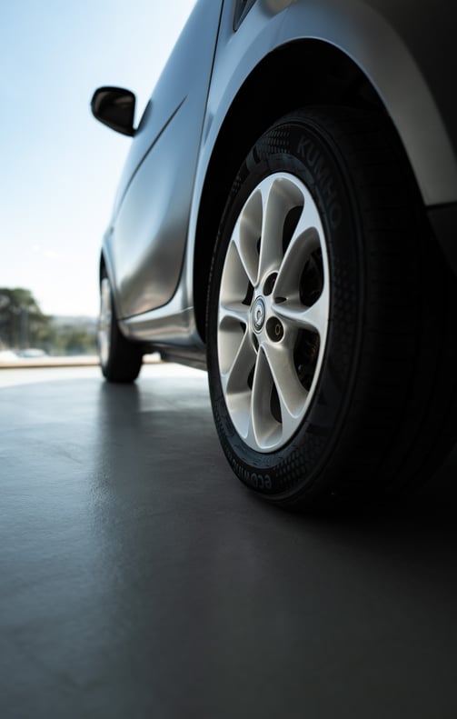 Close-up of a SMART car wheel and side panel on a showroom floor, By ACAT Photos