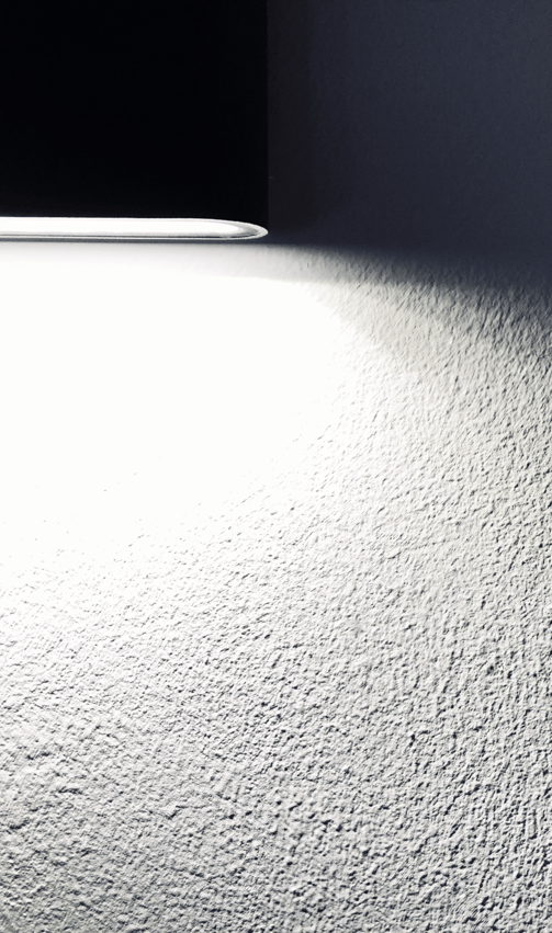 Textured home interior wall lit by spotlight, suitable for illustrating hidden damages assessed during insurance claims.