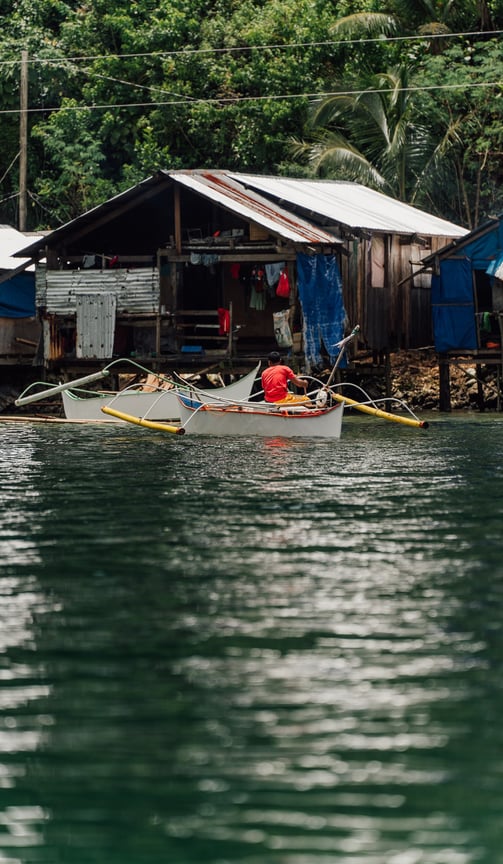 a man in a red shirt is rowing a boat