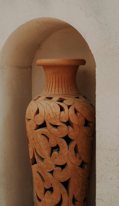 Vaso de barro esculpido, símbolo de ancoragem, elegância natural e contenção energética