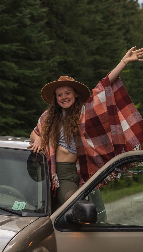 Solana Crowe waving out a car window in banff