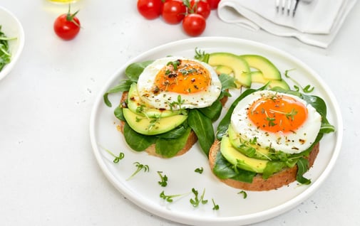 Avocado toast with egg on top sprinkled with parsley