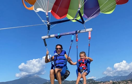 a women and a girl are parasailing in the water