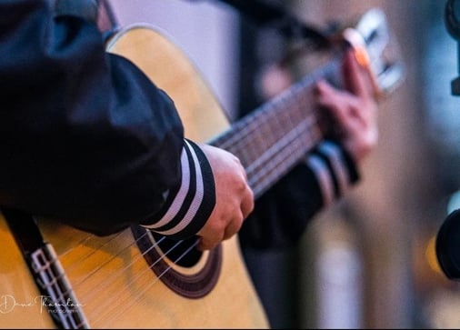 Moss.E playing the nylon-string guitar outside