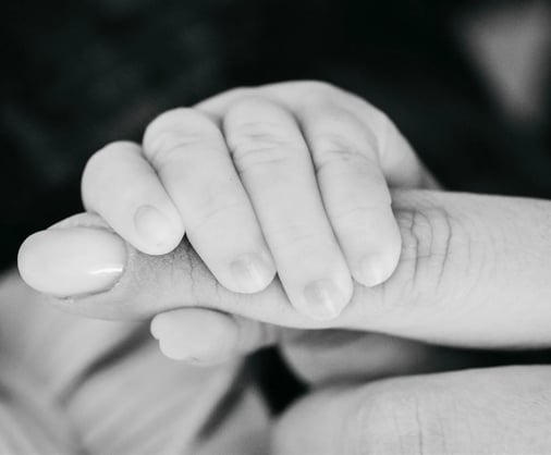Main de bébé serrant le doigt de sa maman – photo de naissance en noir et blanc dans le Gard