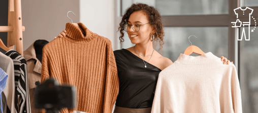 a woman holding a shirt and a sweater