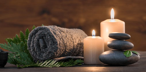 a stack of stones and candles with a roll of towels
