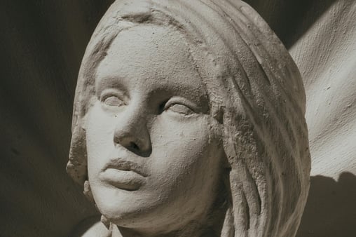 An image of a statue with blank eyes and an expressionless face