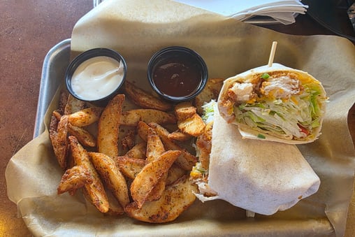 buffalo ranch chicken wrap with potato wedges., a side of ranch and honey bbq sauce from Bdubs