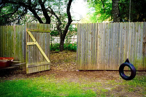 Wooden fence with repaired gate bracing in residential backyard