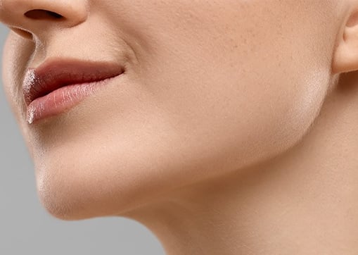 Close-up of a woman's lower face, showing a defined jawline and neck.