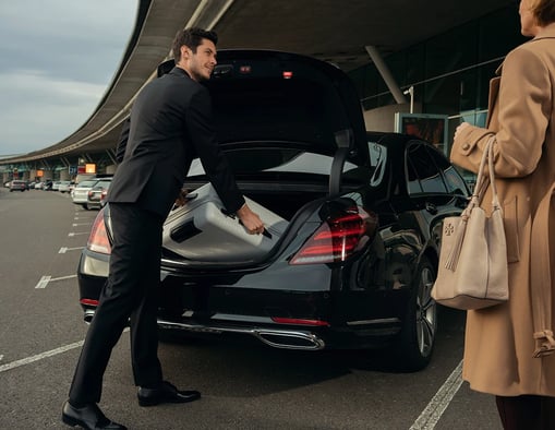 a man and woman standing in front of a car