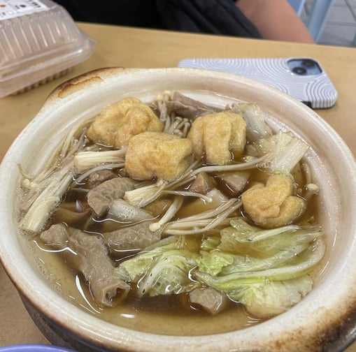 Bak kut teh, a pork bone broth with ribs tofu cabbage enoki mushrooms and pig intestines