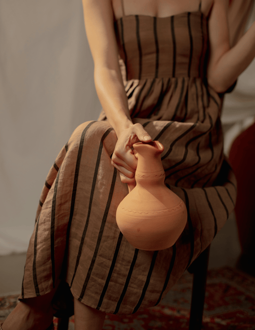 Femme tenant une jarre en terre cuite, symbole de canalisation, ancrage et mémoire intuitive