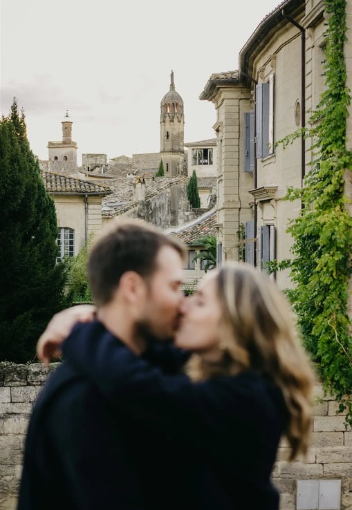 Artistic couple photo with blurred foreground — old stone architecture of Uzès, South of France