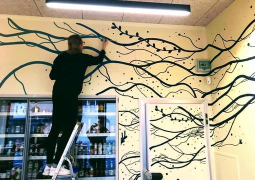 Artiste en cours de réalisation d'une peinture murale 