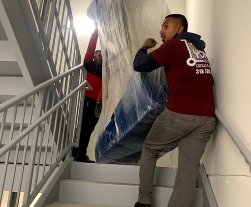 2 movers carrying a couch 