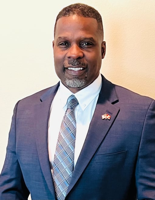 Dr. Marlon Ware professional headshot in blue suit with blue striped tie
