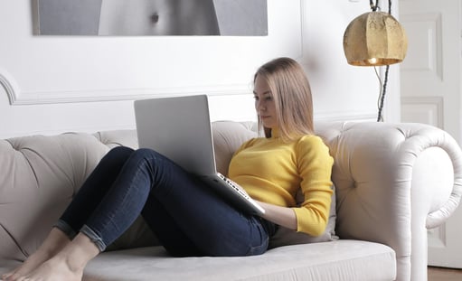Businesswoman writing on PC on a couch