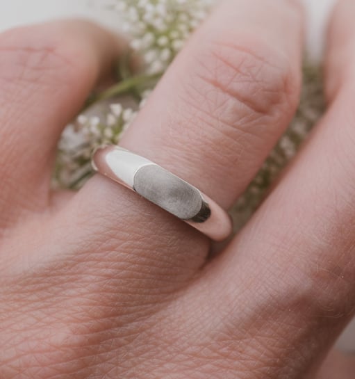 a person's hand holding a ring with a signetring on it