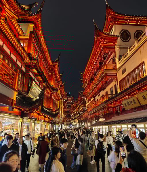 Glowing red buildings alongside busy street