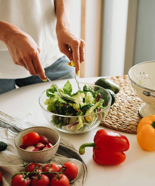 une femme prépare une salade dans un saladier