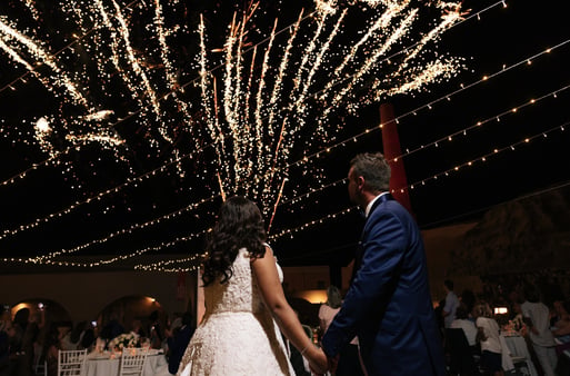 Golden fireworks bursting as the couple makes their unforgettable wedding entrance.