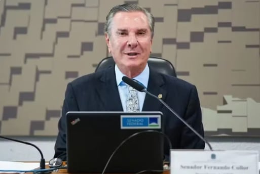 a man in a suit and tie is sitting at a desk