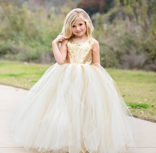 young lady in a beautiful sequined gold and cream party dress