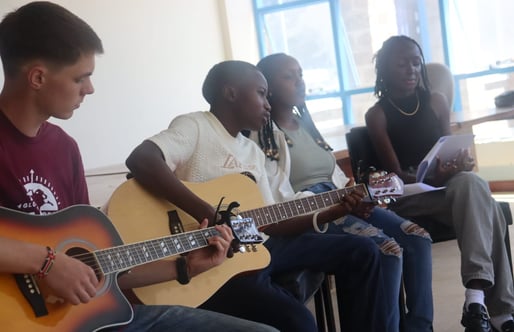 a group of people sitting around a guitar