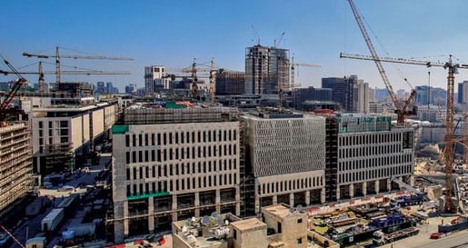a city skyline view of a city with a lot of construction cranes