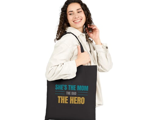 a woman holding a black bag with a message she's the hero