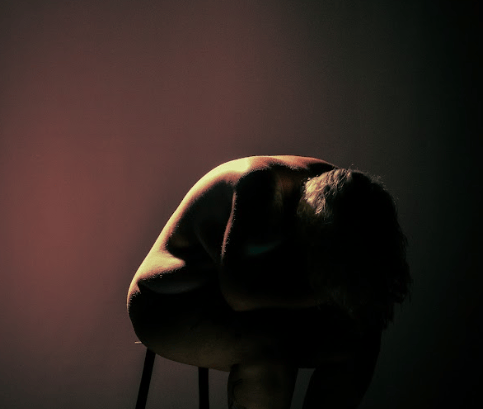 a man sitting on a chair in a dark room