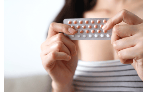 a woman holding a pill pack of pills