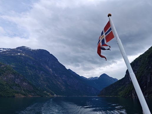 Flag and mast with river and mountain view in Norway