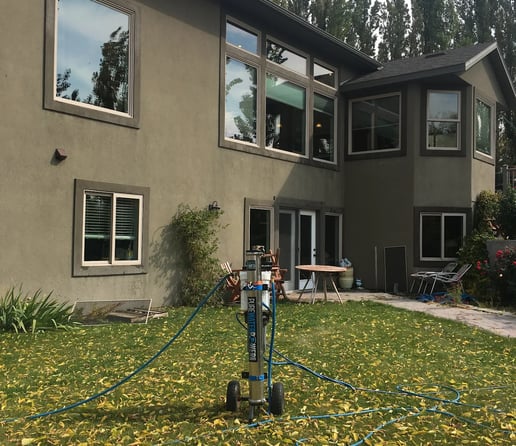 a man is using a hose to clean the lawn